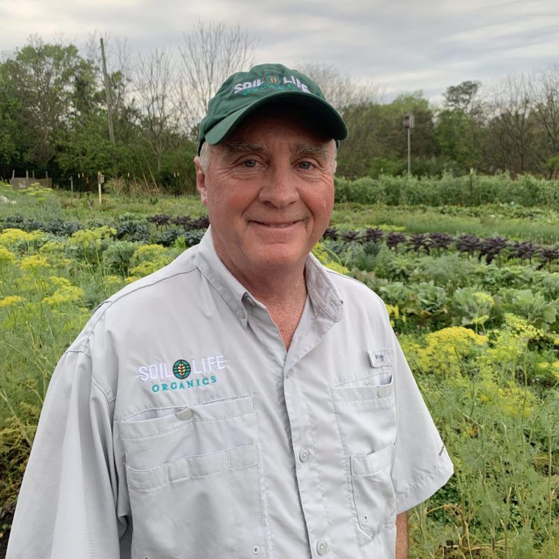 A portrait photo of Allen Skinner with a agricultural field on the background.