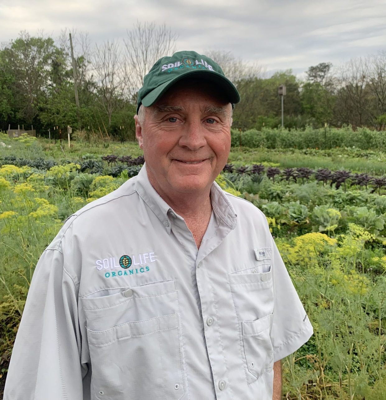 A portrait photo of Allen Skinner with a agricultural field on the background.